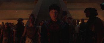 Movie still from “Eternals” (2021), directed by Chloé Zhao – A group of people standing in a room; Medium shot, Low angle