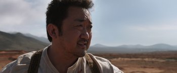 Movie still from “Eternals” (2021), directed by Chloé Zhao – A person wearing a shirt and tie; Close Up shot, Low angle