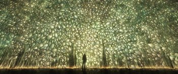 Movie still from “Eternals” (2021), directed by Chloé Zhao – A person standing in front of a wall of rocks; Extreme Wide shot, Low angle