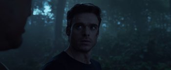 Movie still from “Eternals” (2021), directed by Chloé Zhao – A person looking at the camera; Close Up shot, Low angle