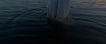 Movie still from “Eternals” (2021), directed by Chloé Zhao – A woman in a white dress standing in the water; Medium shot, Low angle