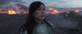 Movie still from “Eternals” (2021), directed by Chloé Zhao – A woman wearing a green and silver costume; Close Up shot, Over the shoulder angle