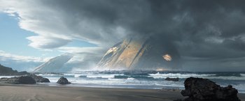 Movie still from “Eternals” (2021), directed by Chloé Zhao – A view of a large rock in the middle of the ocean; Extreme Wide shot, Low angle