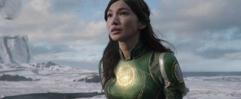 Movie still from “Eternals” (2021), directed by Chloé Zhao – A woman in a green outfit looking at the sky; Close Up shot, Low angle