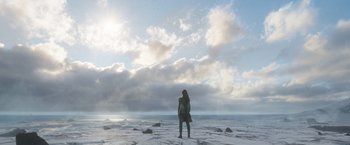 Movie still from “Eternals” (2021), directed by Chloé Zhao – A woman standing on the beach looking out at the ocean; Extreme Wide shot, Low angle