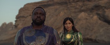 Movie still from “Eternals” (2021), directed by Chloé Zhao – A man and a woman dressed in costumes; Medium shot, Low angle