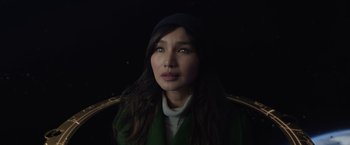 Movie still from “Eternals” (2021), directed by Chloé Zhao – A person with long hair wearing a hat; Close Up shot, High angle
