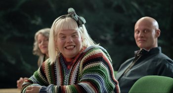 Movie still from “Eurovision Song Contest: The Story of Fire Saga” (2020), directed by David Dobkin – A woman with blonde hair wearing a multicolored sweater; Close Up shot, High angle