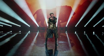 Movie still from “Eurovision Song Contest: The Story of Fire Saga” (2020), directed by David Dobkin – A man standing on a stage in front of an elephant; Wide shot, Low angle