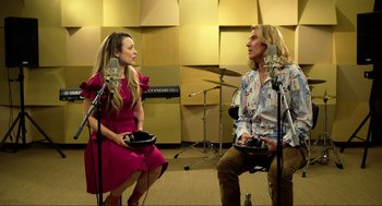 Movie still from “Eurovision Song Contest: The Story of Fire Saga” (2020), directed by David Dobkin – A man and a woman sitting in front of microphones in a recording studio; Medium shot, High angle