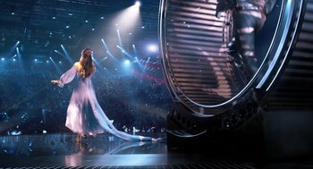Movie still from “Eurovision Song Contest: The Story of Fire Saga” (2020), directed by David Dobkin – A woman in a long dress standing in front of an audience; Wide shot, Low angle