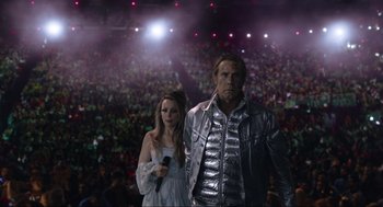 Movie still from “Eurovision Song Contest: The Story of Fire Saga” (2020), directed by David Dobkin – A man and a woman are standing in front of a crowd; Medium shot, Low angle