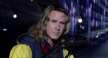 Movie still from “Eurovision Song Contest: The Story of Fire Saga” (2020), directed by David Dobkin – A man with long blonde hair is speaking into a microphone; Close Up shot, Low angle