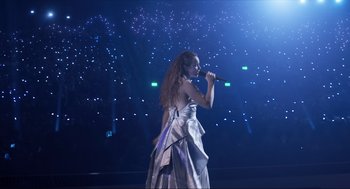 Movie still from “Eurovision Song Contest: The Story of Fire Saga” (2020), directed by David Dobkin – A woman in a silver dress singing on a stage; Extreme Wide shot, Low angle