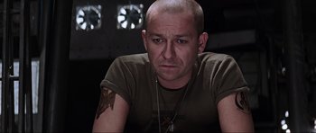 Movie still from “Event Horizon” (1997), directed by Paul W.S. Anderson – A man with a tattoo is sitting in a dark room; Close Up shot, Over the shoulder angle