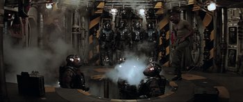 Movie still from “Event Horizon” (1997), directed by Paul W.S. Anderson – A group of men in shiny black suits and helmets; Wide shot, High angle