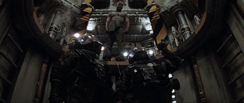 Movie still from “Event Horizon” (1997), directed by Paul W.S. Anderson – A group of men standing next to each other in a building; Wide shot, Low angle
