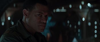 Movie still from “Event Horizon” (1997), directed by Paul W.S. Anderson – A man's face in a dark room; Close Up shot, Over the shoulder angle