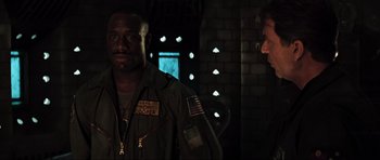 Movie still from “Event Horizon” (1997), directed by Paul W.S. Anderson – A man and a woman standing next to each other in the dark; Medium shot, Over the shoulder angle