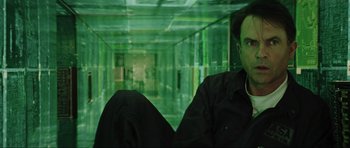 Movie still from “Event Horizon” (1997), directed by Paul W.S. Anderson – A man sitting on a couch in a room with green walls; Medium shot, High angle