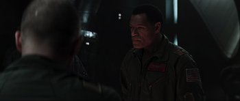Movie still from “Event Horizon” (1997), directed by Paul W.S. Anderson – A man in a military uniform looking at another man in a military uniform; Close Up shot, Over the shoulder angle