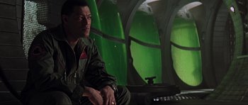 Movie still from “Event Horizon” (1997), directed by Paul W.S. Anderson – A man sitting on a chair in front of a window; Close Up shot, Low angle