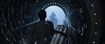 Movie still from “Event Horizon” (1997), directed by Paul W.S. Anderson – A man standing inside of a tunnel looking at a man riding a bike; Medium shot, Low angle