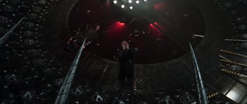 Movie still from “Event Horizon” (1997), directed by Paul W.S. Anderson – A man standing on a stage in front of lights; Wide shot, Overhead angle