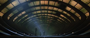 Movie still from “Event Horizon” (1997), directed by Paul W.S. Anderson – Two people are standing in a tunnel of a train station; Extreme Wide shot, Low angle