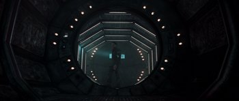 Movie still from “Event Horizon” (1997), directed by Paul W.S. Anderson – A man standing inside of a building with lights; Wide shot, Low angle