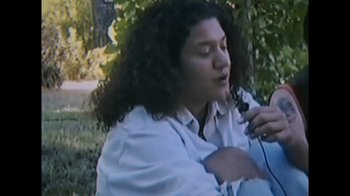 Movie still from “Every Body” (2023), directed by Julie Cohen – A person with long hair is holding a microphone; Close Up shot, Low angle