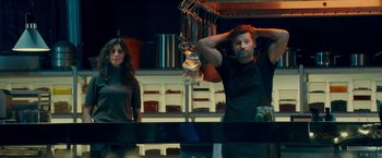 Movie still from “A Taste of Hunger” (2021), directed by Christoffer Boe – A man and a woman standing in a kitchen; Medium shot, Low angle