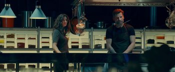 Movie still from “A Taste of Hunger” (2021), directed by Christoffer Boe – A man and a woman standing next to a counter; Medium shot, Low angle