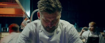 Movie still from “A Taste of Hunger” (2021), directed by Christoffer Boe – A person wearing a white shirt; Close Up shot, Low angle