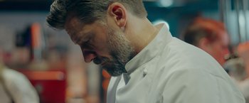 Movie still from “A Taste of Hunger” (2021), directed by Christoffer Boe – A person wearing a white shirt; Close Up shot, Low angle