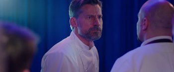 Movie still from “A Taste of Hunger” (2021), directed by Christoffer Boe – A person wearing a chef's outfit; Close Up shot, Over the shoulder angle