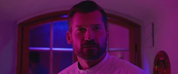 Movie still from “A Taste of Hunger” (2021), directed by Christoffer Boe – A person wearing a white shirt; Close Up shot, Low angle