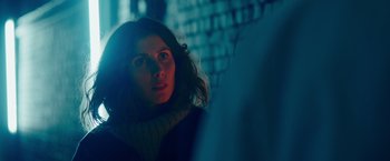 Movie still from “A Taste of Hunger” (2021), directed by Christoffer Boe – A woman is looking into the distance in the dark; Close Up shot, Over the shoulder angle