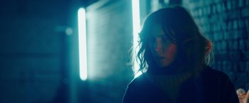 Movie still from “A Taste of Hunger” (2021), directed by Christoffer Boe – A young woman standing next to a wall in the dark; Close Up shot, Low angle