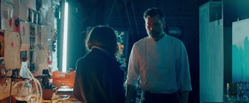 Movie still from “A Taste of Hunger” (2021), directed by Christoffer Boe – A man and a woman standing next to each other in a room; Medium shot, Over the shoulder angle