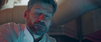 Movie still from “A Taste of Hunger” (2021), directed by Christoffer Boe – A person wearing a white shirt; Close Up shot, Low angle