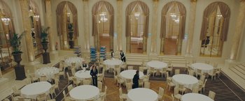Movie still from “A Taste of Hunger” (2021), directed by Christoffer Boe – A group of people sitting at tables in a room; Extreme Wide shot, High angle