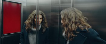 Movie still from “A Taste of Hunger” (2021), directed by Christoffer Boe – A woman standing in front of a mirror in an elevator; Close Up shot, Over the shoulder angle