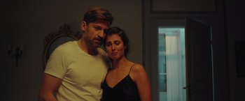 Movie still from “A Taste of Hunger” (2021), directed by Christoffer Boe – A man and a woman standing next to each other in a room; Close Up shot, Low angle