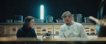 Movie still from “A Taste of Hunger” (2021), directed by Christoffer Boe – A man and a woman sitting at a table in a kitchen; Medium shot, Low angle