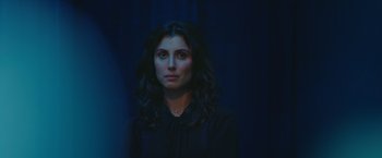 Movie still from “A Taste of Hunger” (2021), directed by Christoffer Boe – A woman in a black shirt is standing in a dark room; Close Up shot, Over the shoulder angle