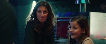 Movie still from “A Taste of Hunger” (2021), directed by Christoffer Boe – A woman sitting next to a young girl in a room; Close Up shot, Over the shoulder angle