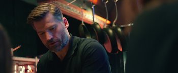 Movie still from “A Taste of Hunger” (2021), directed by Christoffer Boe – A person sitting in front of pans; Close Up shot, Low angle