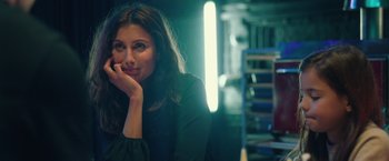 Movie still from “A Taste of Hunger” (2021), directed by Christoffer Boe – A beautiful woman sitting in a dark room; Close Up shot, Over the shoulder angle