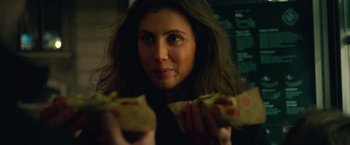 Movie still from “A Taste of Hunger” (2021), directed by Christoffer Boe – A woman holding a sandwich in her hands; Close Up shot, Over the shoulder angle